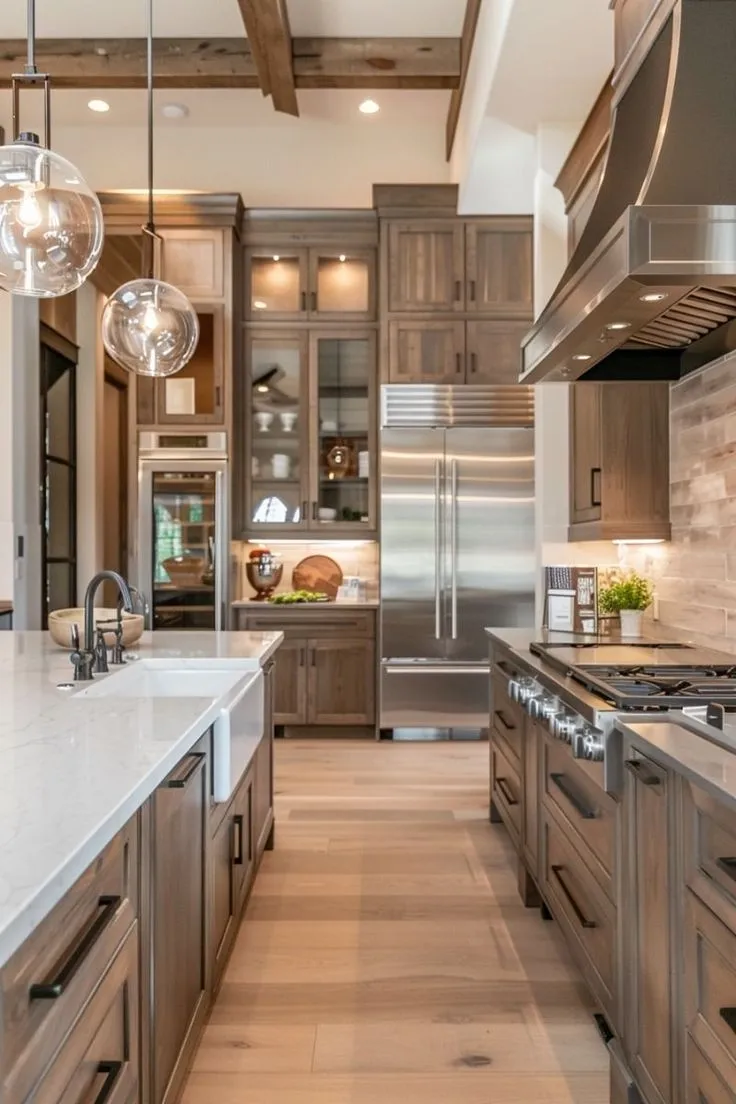 Open shelving and sleek cabinetry bring functionality to this kitchen. Exposed wood beams and glass pendant lights add industrial character. This design blends practicality with modern flair.