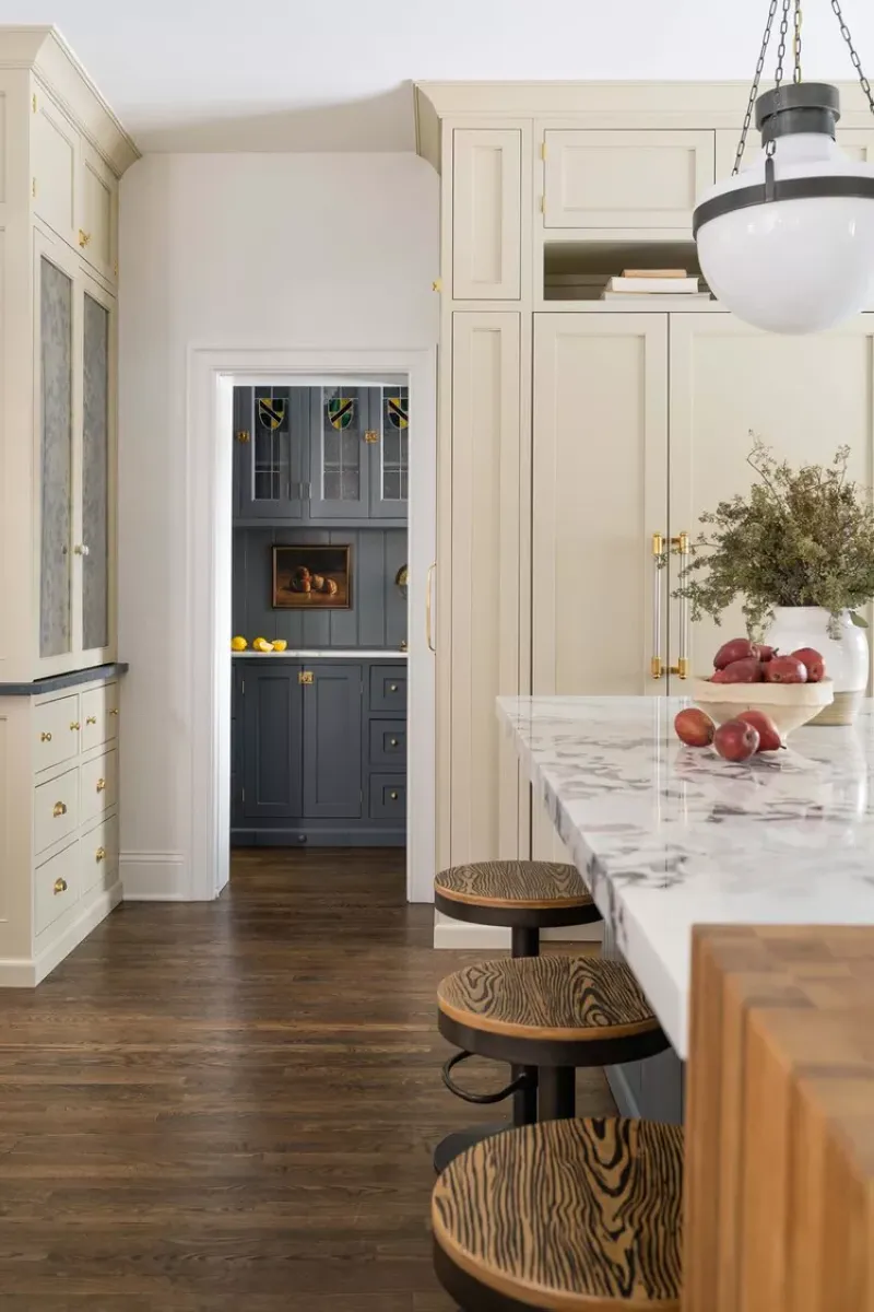 Traditional Elegance with Gold Accents This light and airy kitchen island pairs soft white tones with subtle gold handles for a refined look. The addition of a vintage-inspired rug brings warmth to the space. To stay within budget, look for secondhand rugs or replicas and use adhesive gold decals for existing hardware.