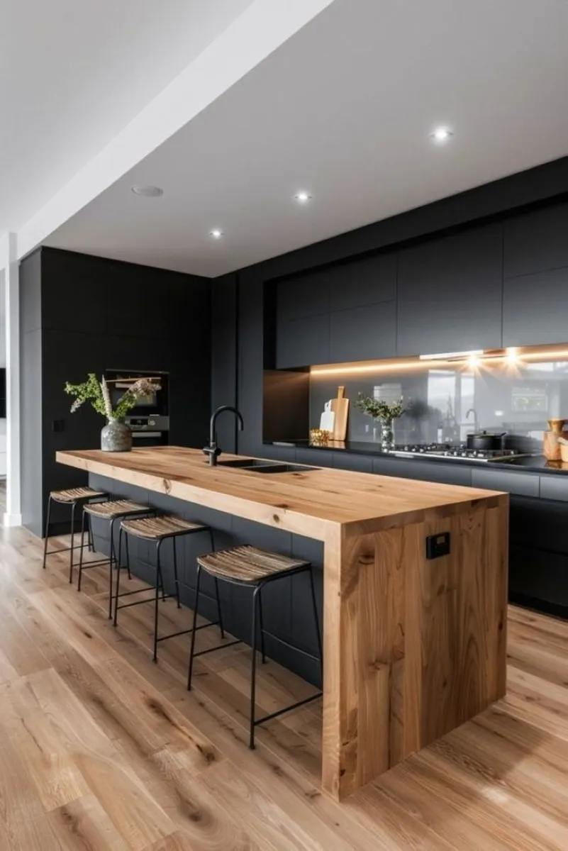 Minimalist Black and Wood Island A streamlined black and wood kitchen island stands out with its clean lines and natural tones. The wooden countertop brings warmth, while the black finish adds sophistication. To replicate this design affordably, repurpose existing materials by painting cabinets black and investing in an inexpensive wood slab for the counter. Add woven bar stools for a touch of texture.