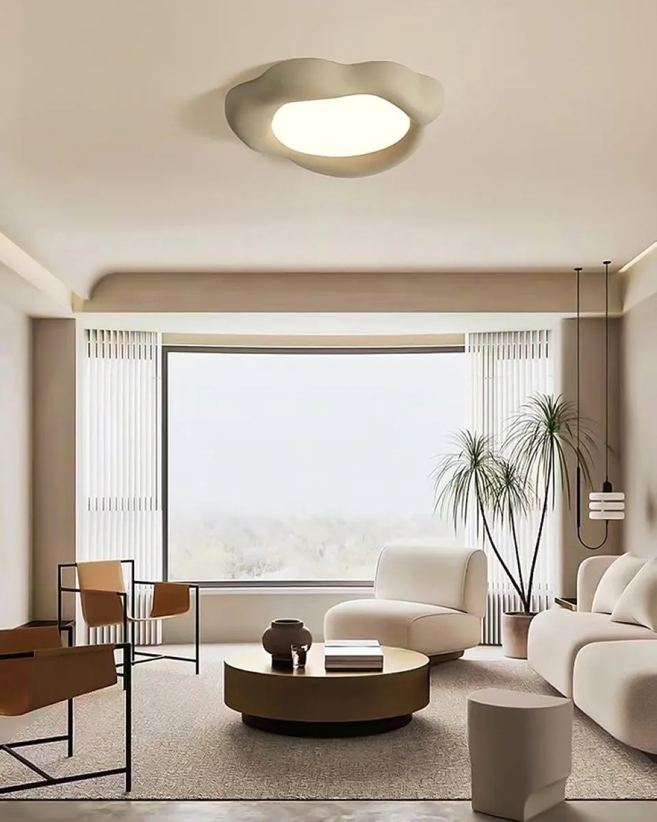 A sculptural ceiling light can define the room's atmosphere. In this image, the organic shape of the light fixture blends elegance with creativity. Its soft illumination highlights the clean, minimalist lines of the furniture, creating a harmonious space that feels both warm and modern. 