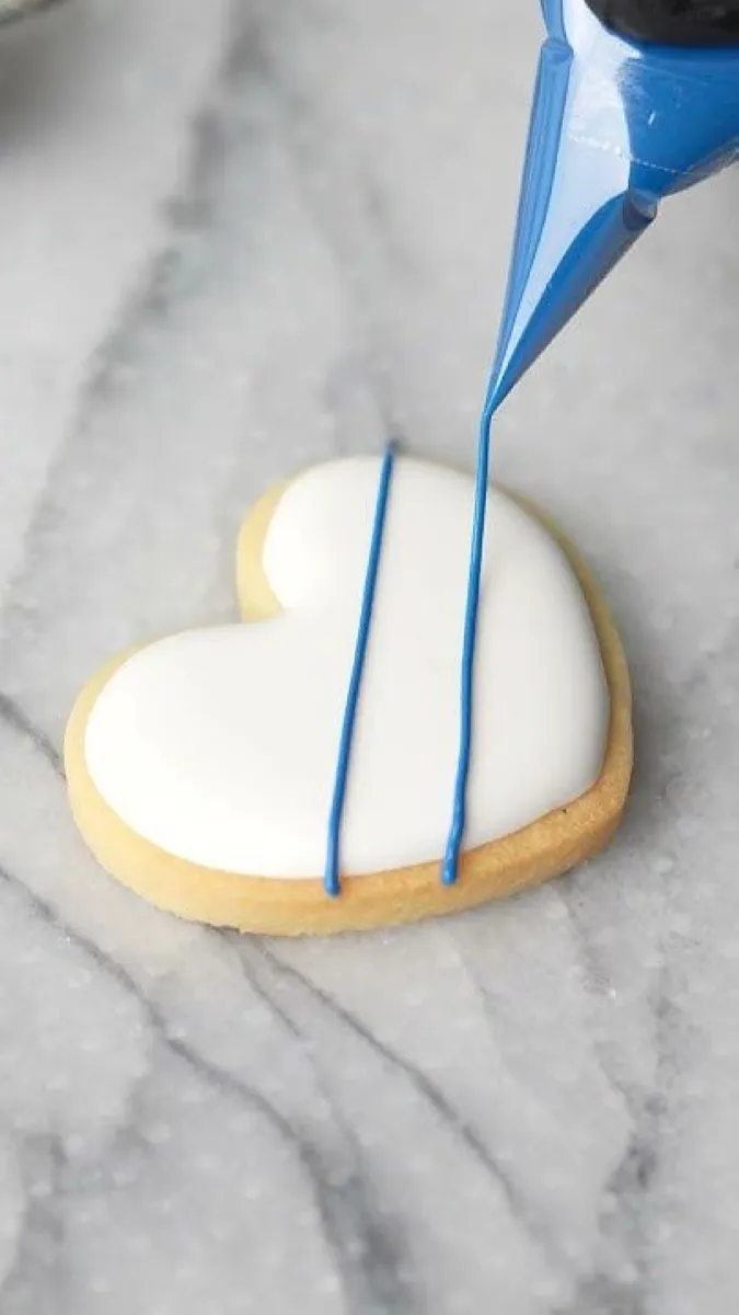 Royal Icing Designs Use royal icing to create elegant designs such as lace patterns, names, or tiny hearts on your cookies. The key is to outline the cookies first, then flood them with thinned icing for a smooth finish.