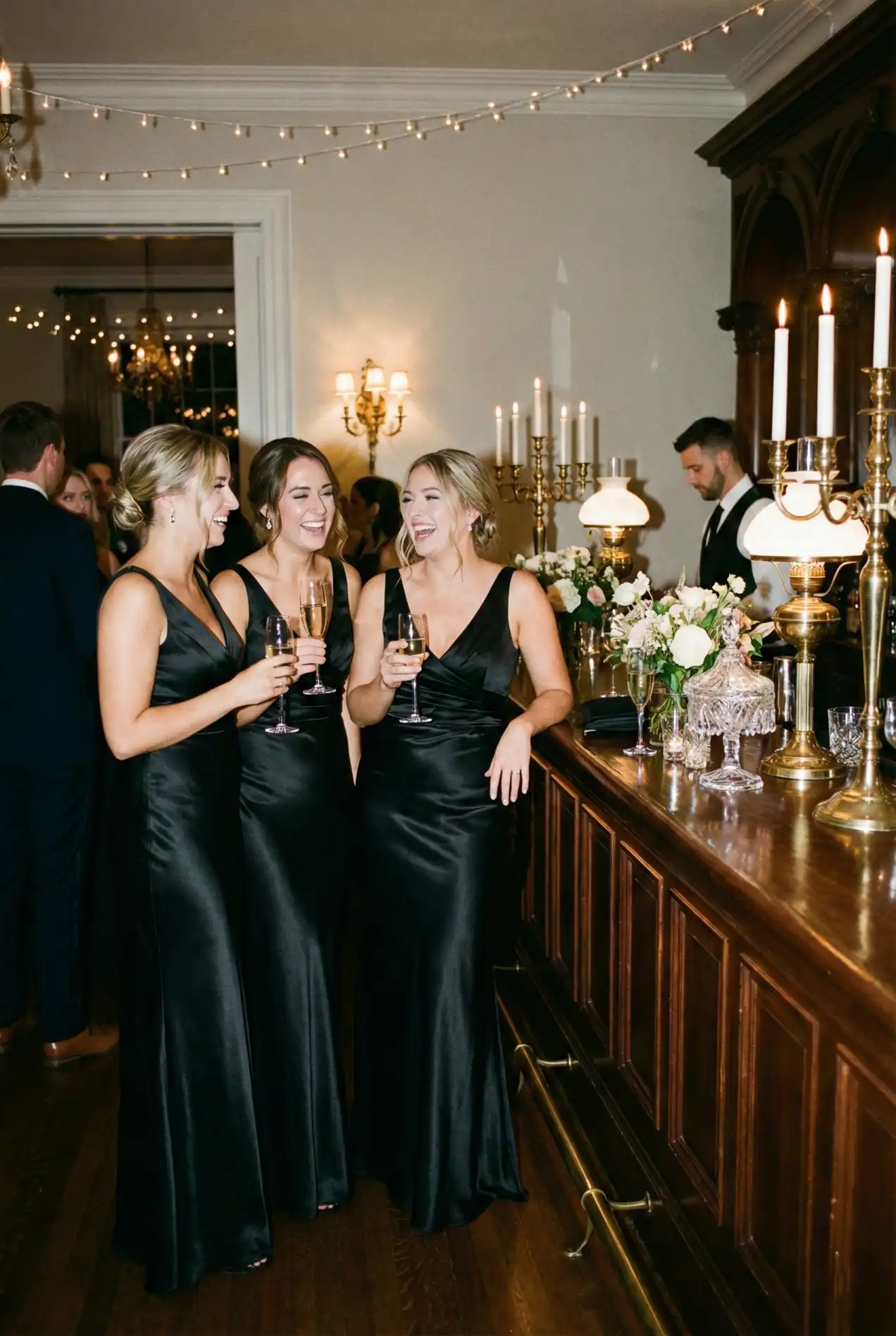Elegant black bridesmaid dresses for a modern black-tie wedding. Chic satin evening dresses 2026 trends. Wedding party inspiration featuring floor-length black gowns and glam dresses for a sophisticated city wedding.