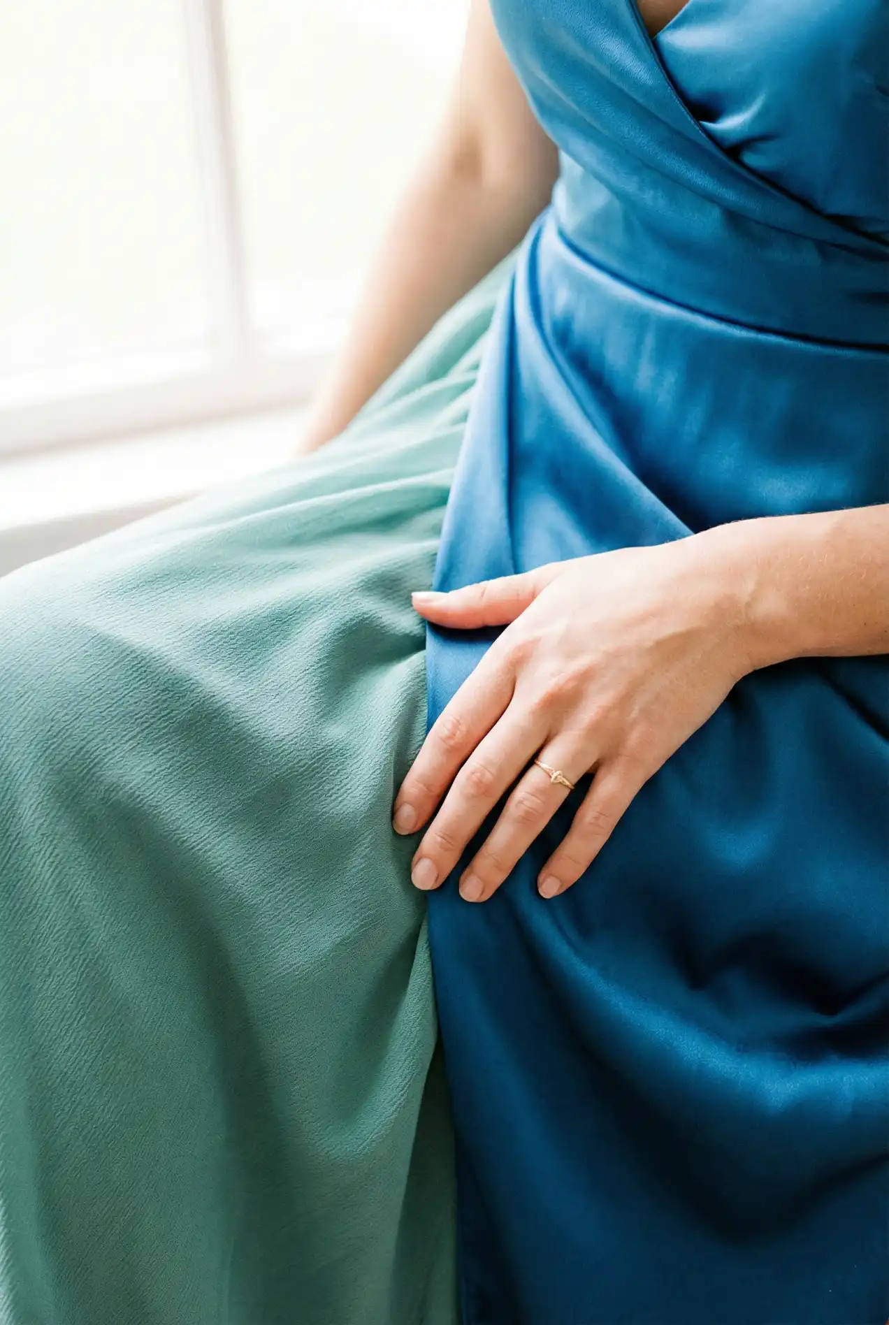 Fabric details for 2026 weddings: Blue satin bridesmaid dresses mixed with matte chiffon textures. Close up of high-quality evening gown fabrics. Perfect for styling a blue wedding palette with dusty blue and navy tones