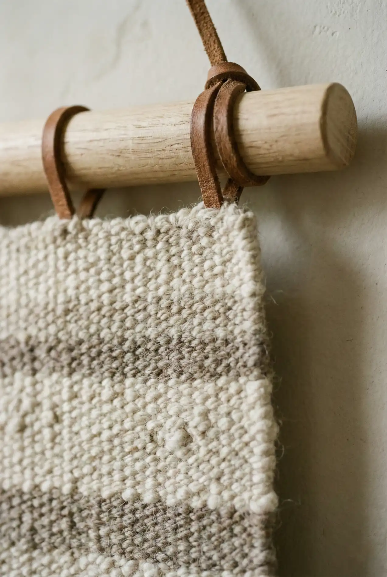 Don't just tack it up! Here is the easy, elevated way to hang fabric and tapestries using a wooden dowel and leather straps. A simple weekend project.