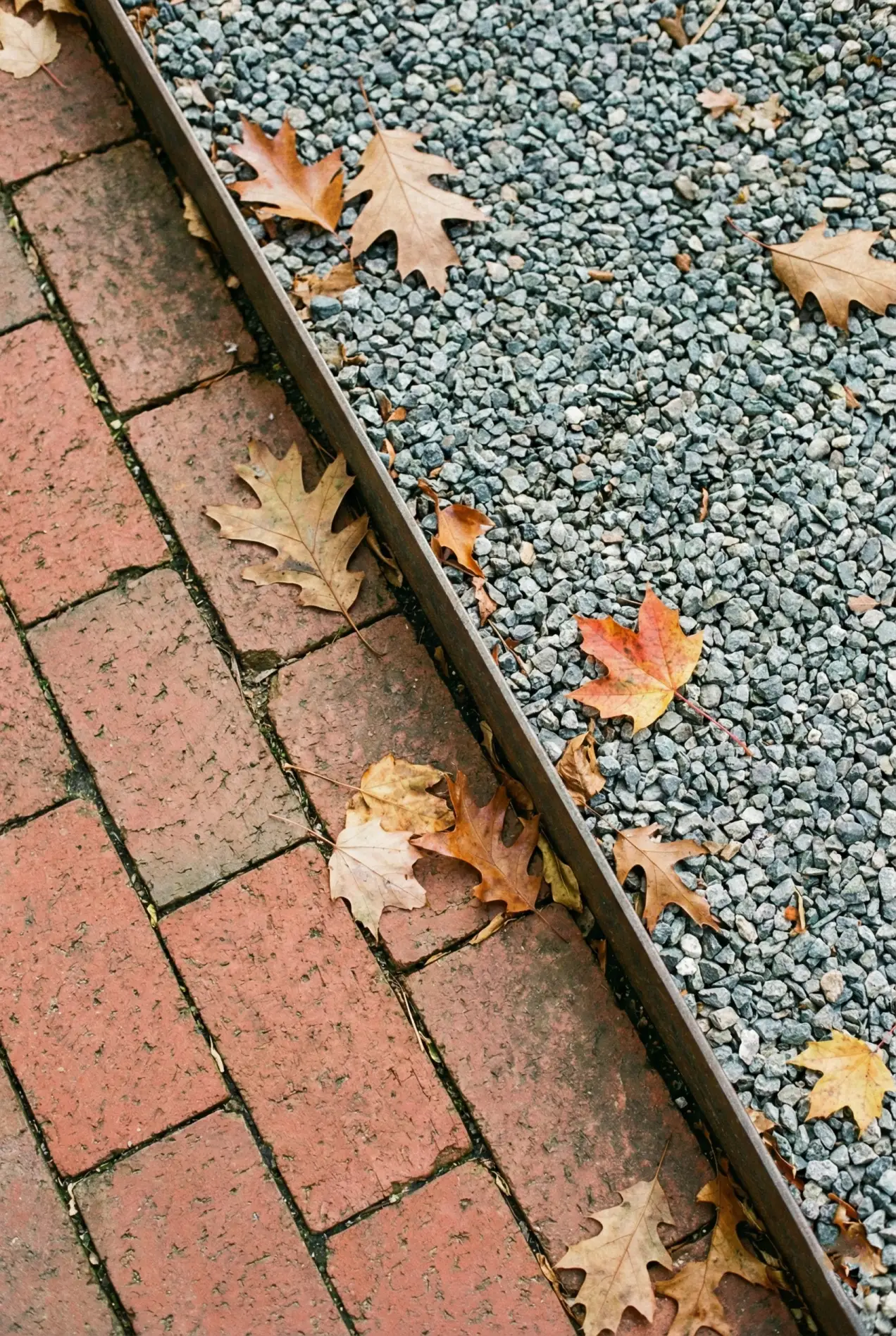 Stop using boring pavers. See how mixing materials like brick and gravel adds instant character to your hardscaping. #hardscapedesign #patioideas