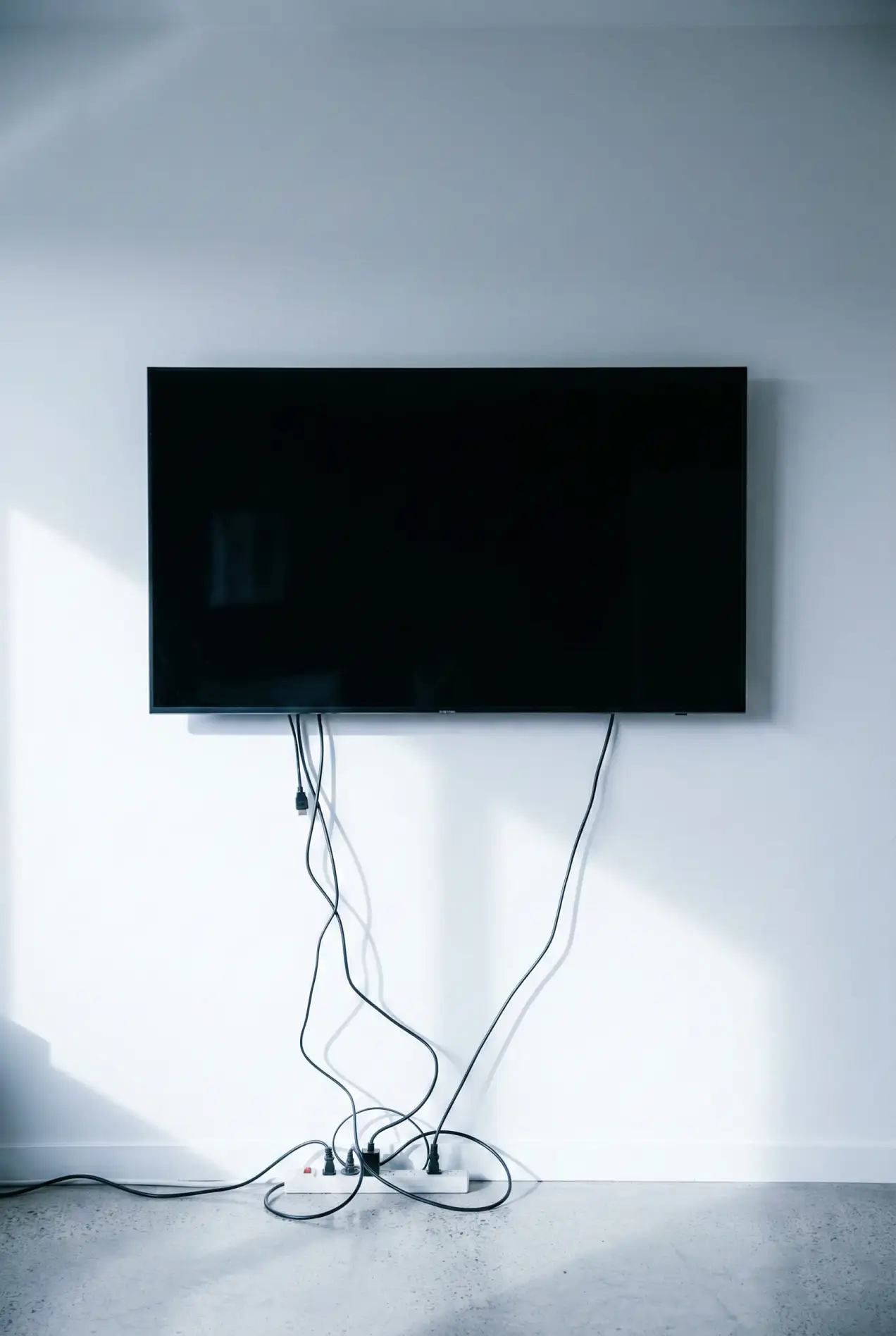 Hate the big black box in your living room? Don't buy a frame TV. Just use this specific paint color to camouflage it. It's the easiest weekend DIY for a cozy, expensive-looking home. #camouflagetv #darkwalls #livingroomideas #diyhomedecor