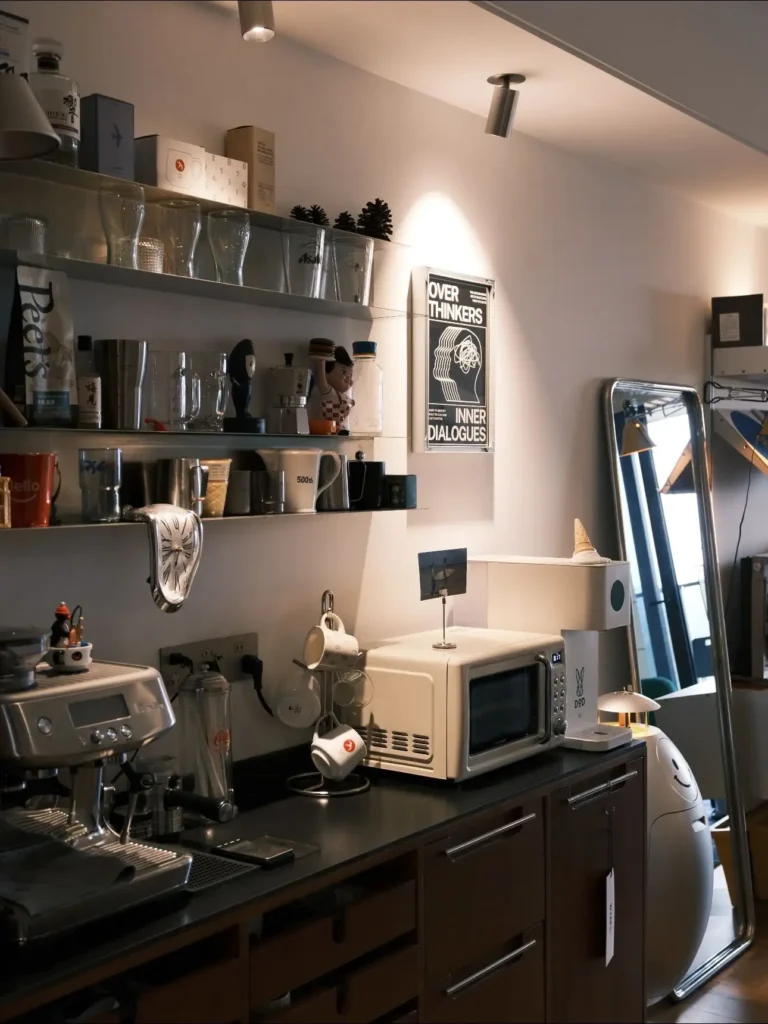 Open shelves can turn a simple coffee station into a stylish focal point. Glassware, mugs, and small decor objects create a curated look that feels both functional and beautiful. Save this if you love cozy kitchen corners. #openshelving #coffeestation #kitchenstyling #apartmentdecor #homedecorideas #curatedinterior #kitcheninspiration #cozyhome #smallapartmentideas #interiorstyling
