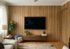 Wood Slat Wall Ideas for Your Living Room (Starting With the TV Wall) Wood slat accent wall behind mounted TV in a living room with natural oak slats, floating console, and warm natural light.