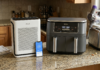 The Only Home Appliances Worth Buying in 2026 (And 4 You Should Skip) Warm kitchen counter with clear space for household appliances, cordless vacuum in background, natural morning light.