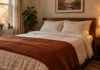 Flannel Sheets for a Small Bedroom: What to Check Before You Buy Small bedroom in fall with cream flannel sheets, a rust waffle-knit blanket at the foot of the bed and a lit lamp on the nightstand