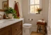 A Small Fall Bathroom Refresh in Three Swaps, No New Fixtures Illustrated small fall bathroom with rust and cream towels, a stool and a plant